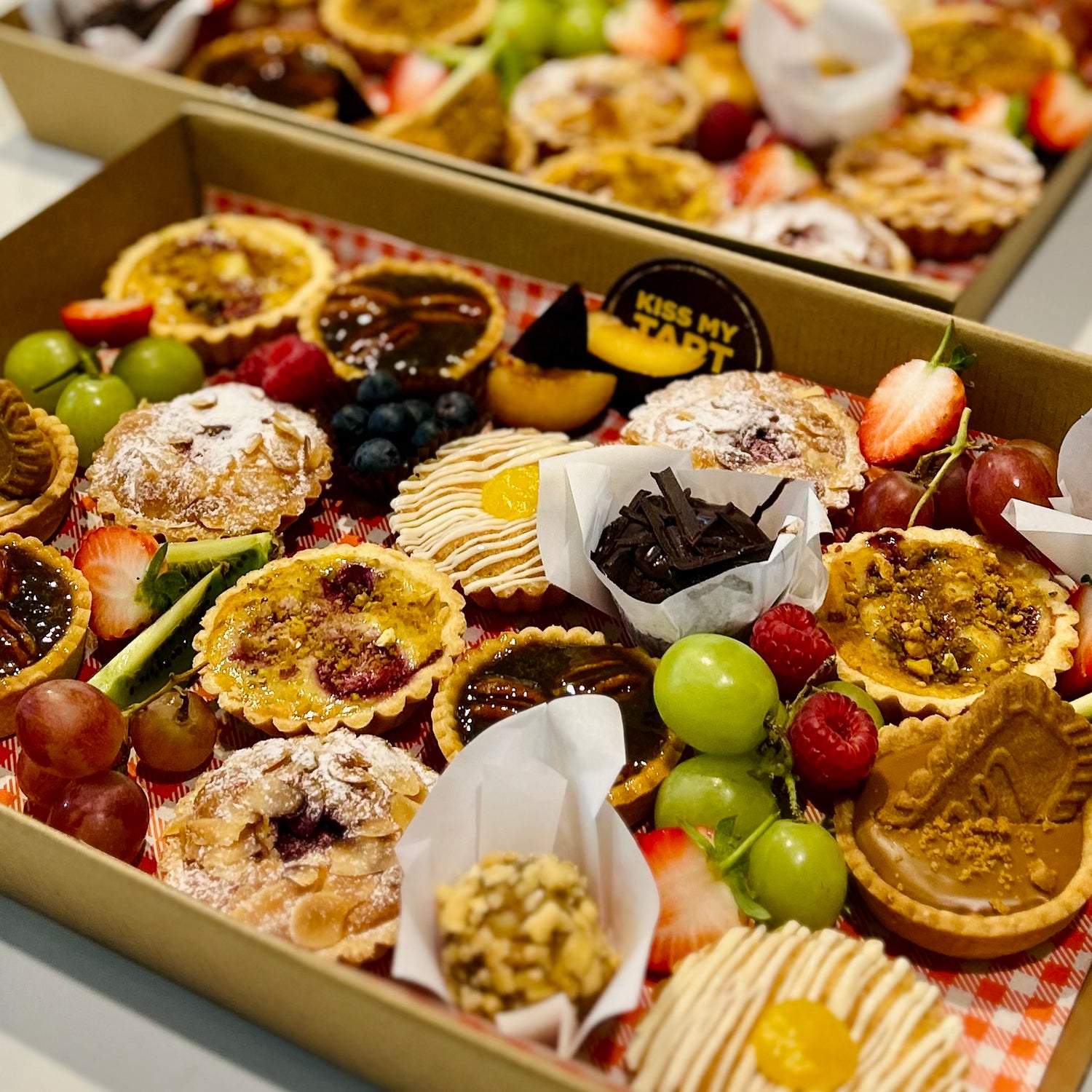 Catering platter of assorted tarts, biscuits and fresh fruit