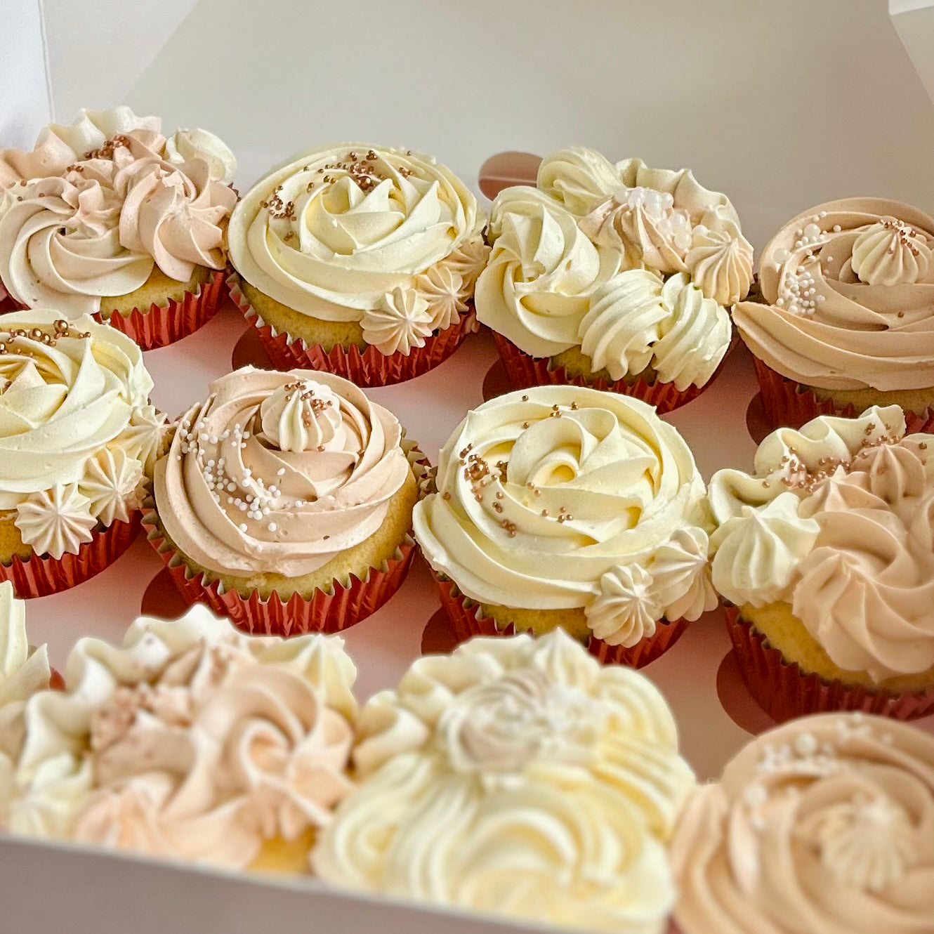 Vanilla cupcakes decorated in neutral buttercream colours