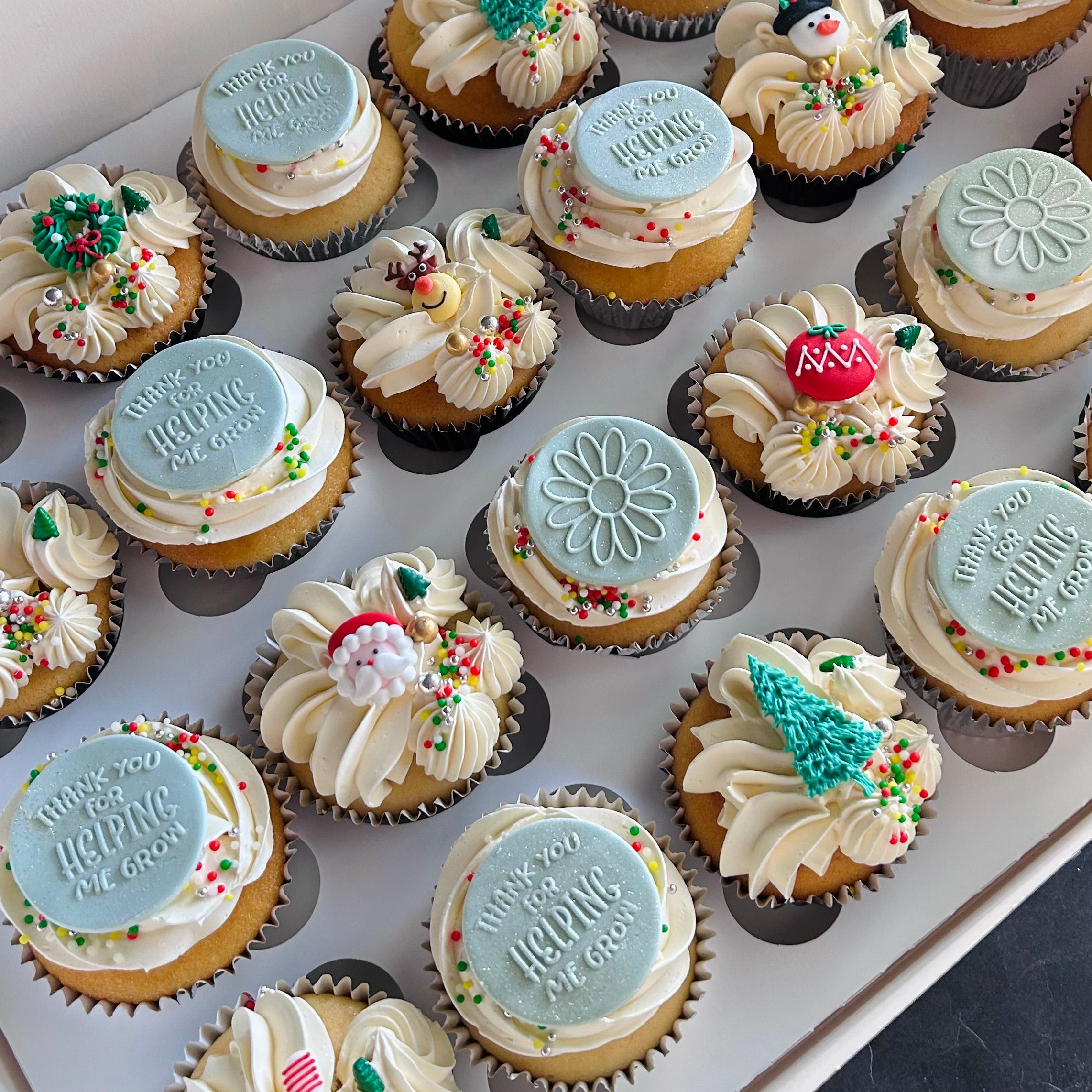 Vanilla cupcakes decorated with fondant "thank you" discs and christmas decorations